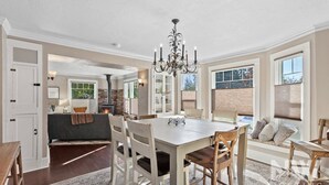 A spacious dining area with a large table and chairs, a chandelier, and a stone fireplace. - Mt 00507 (Coeur d'Alene)