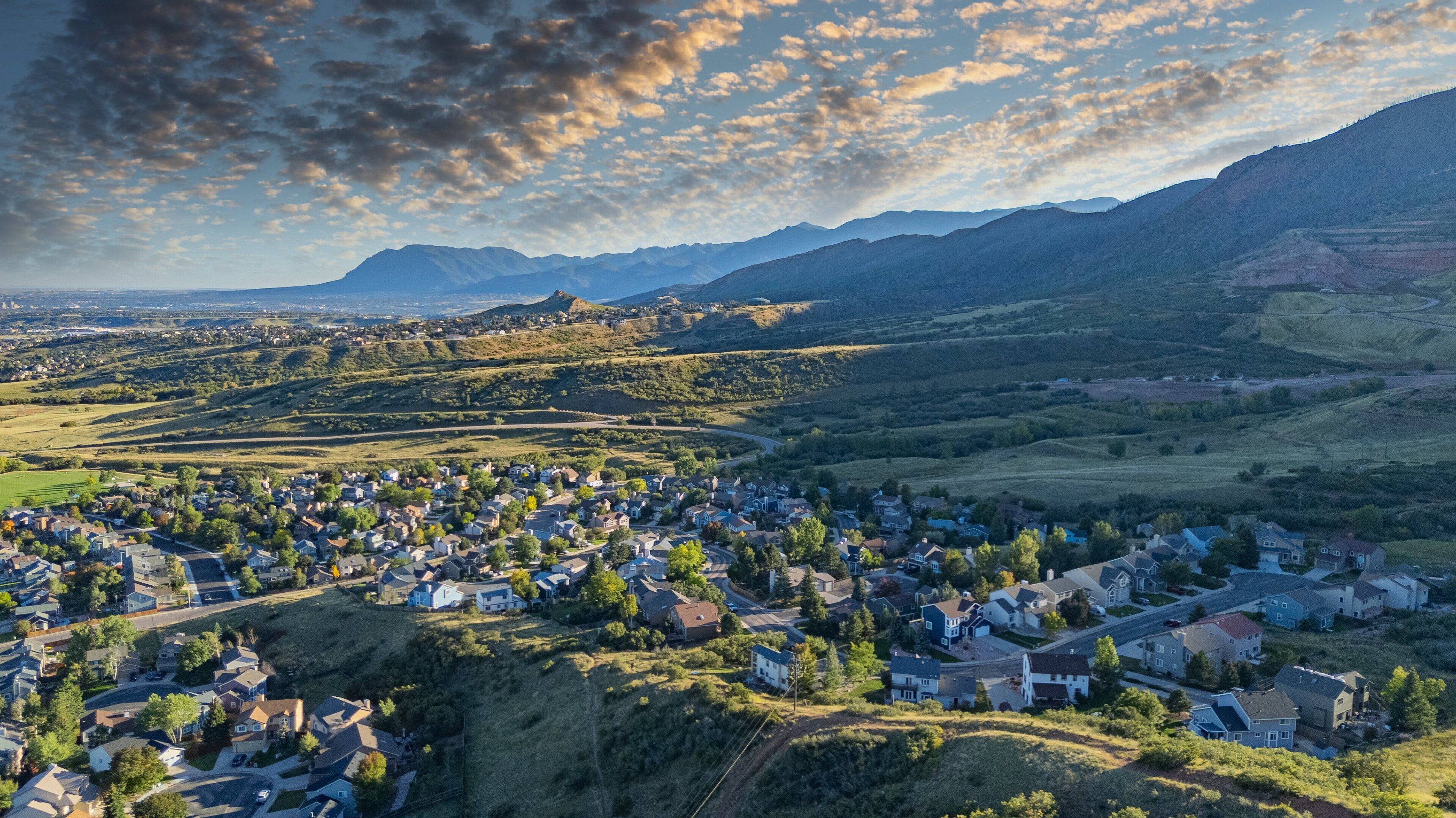 An aerial view of a residential area with houses, roads, and a river.