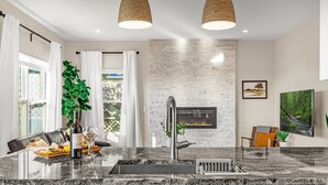 A modern kitchen with a granite countertop, stainless steel sink, and a built-in stove. - Mountain Retreat With Hot Tub & Views (Colorado Springs)