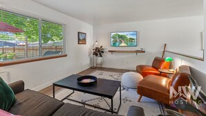 A living room with a sofa, a coffee table, a TV, and a painting on the wall. - Dt 01906 (Coeur d'Alene)