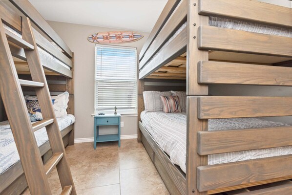 A bunk bed room with a small table and a window with blinds. - Latitude Adjustment - Private Pool Elevator! (Colorado Springs)