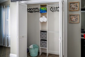 A walk-in closet with shelves, hanging space, and a laundry basket. - Waterfront Twin Townhome, Private Dock, Near Beach (Navarre)