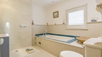 A bathroom with a bathtub, toilet, and shower.