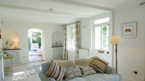 A living room with a light blue sofa, a lamp, and a view of the outside. - Mount Pleasant (Padstow)