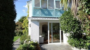 A two-story house with a balcony, a glass door entrance, and a garden area. - Mount Pleasant (Padstow)
