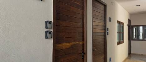 A hallway with two wooden doors, a number sign '103', and a small window.