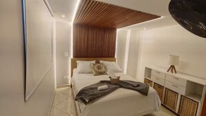 A modern bedroom with a bed, bedside tables, and a ceiling fan. - Your comfortable, elegant, and centrally located space with balcony 401 (Medellín)