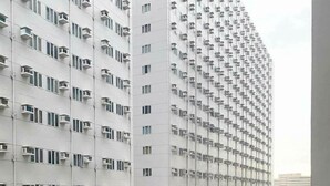 Um edifício alto com várias varandas e aparelhos de ar condicionado.