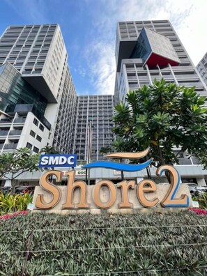 Um edifício moderno e alto com uma placa indicando 'SMDC Shore2'.