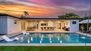 A modern house with a swimming pool, a dining area, and a patio. - Villa Bonita Tropical Paradise Pool (Hollywood)