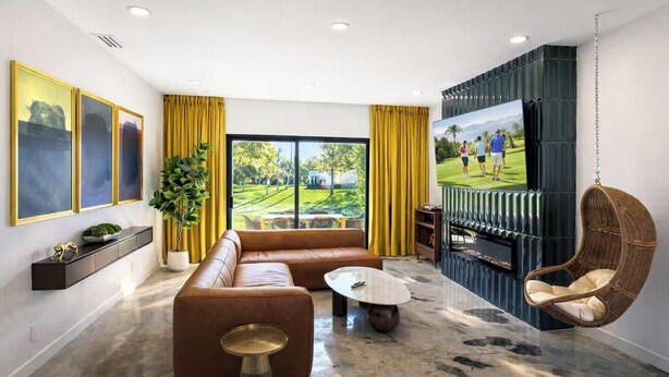 Ein modernes Wohnzimmer mit Sofa, Couchtisch und Fernseher.