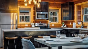 Una cocina moderna con paredes de madera, electrodomésticos de acero inoxidable y una isla central con taburetes de bar.