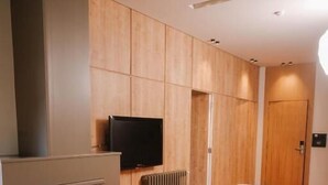 A modern living room with a fireplace, a flat-screen TV, and a sofa. - Hotel ehden (Ehden)