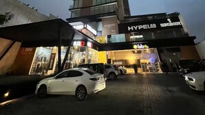 Un edificio moderno con un diseño angular distintivo, que presenta una entrada destacada con el letrero 'HYPELAB' y 'HANDBODY'.