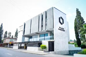 Un bâtiment moderne sur lequel on peut lire l’inscription « PLAZA CIENTO ».