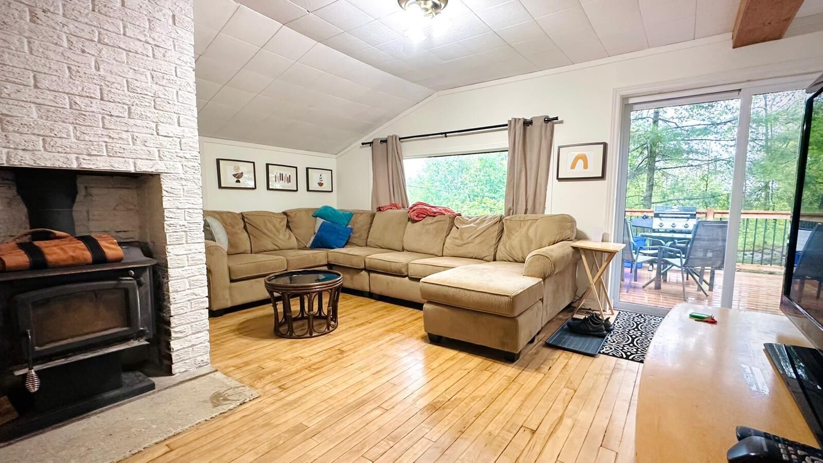 A living room with a fireplace, a sofa set, a coffee table, and a view of the outdoors.