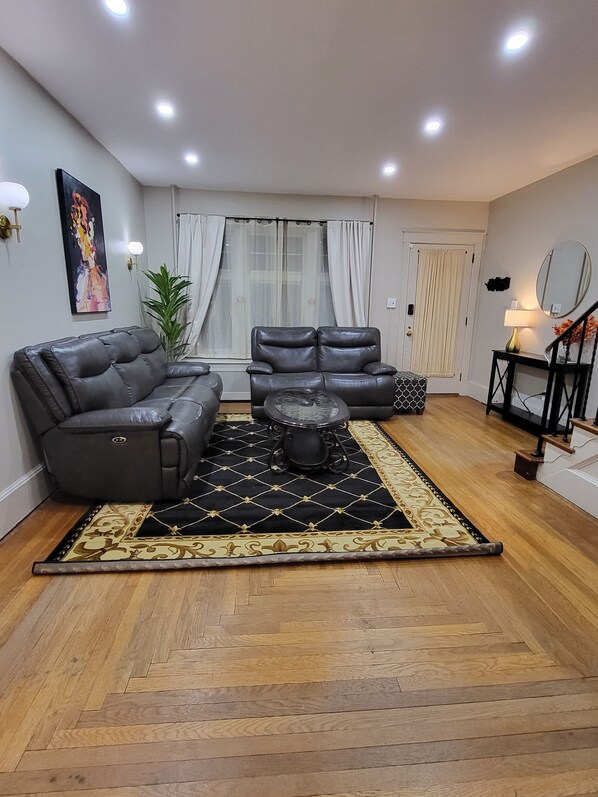 A modern living room with a sectional sofa, a coffee table, and a patterned rug.
