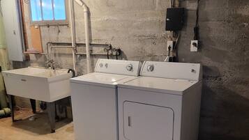 Een wasserette met twee wasmachines en een wasbak.