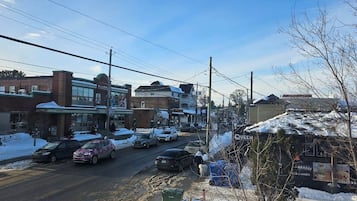 A street view with buildings, cars, and a sign for 'Queen.'