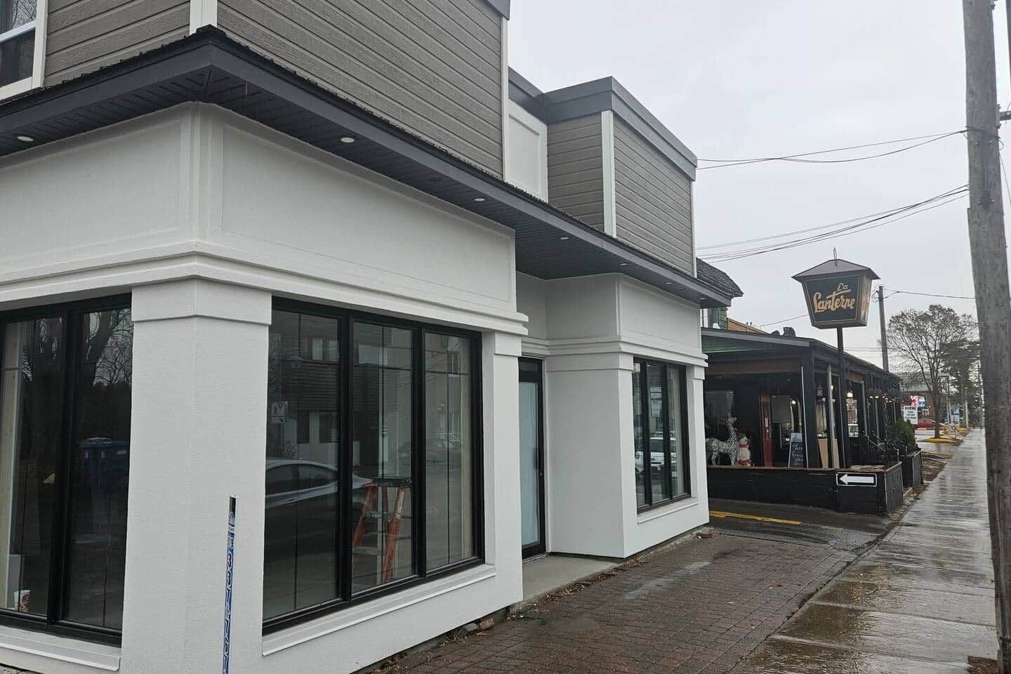 En bygning med store vinduer og en butiksfacade med et skilt.