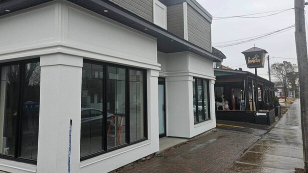 A building with large windows and a storefront with a sign.