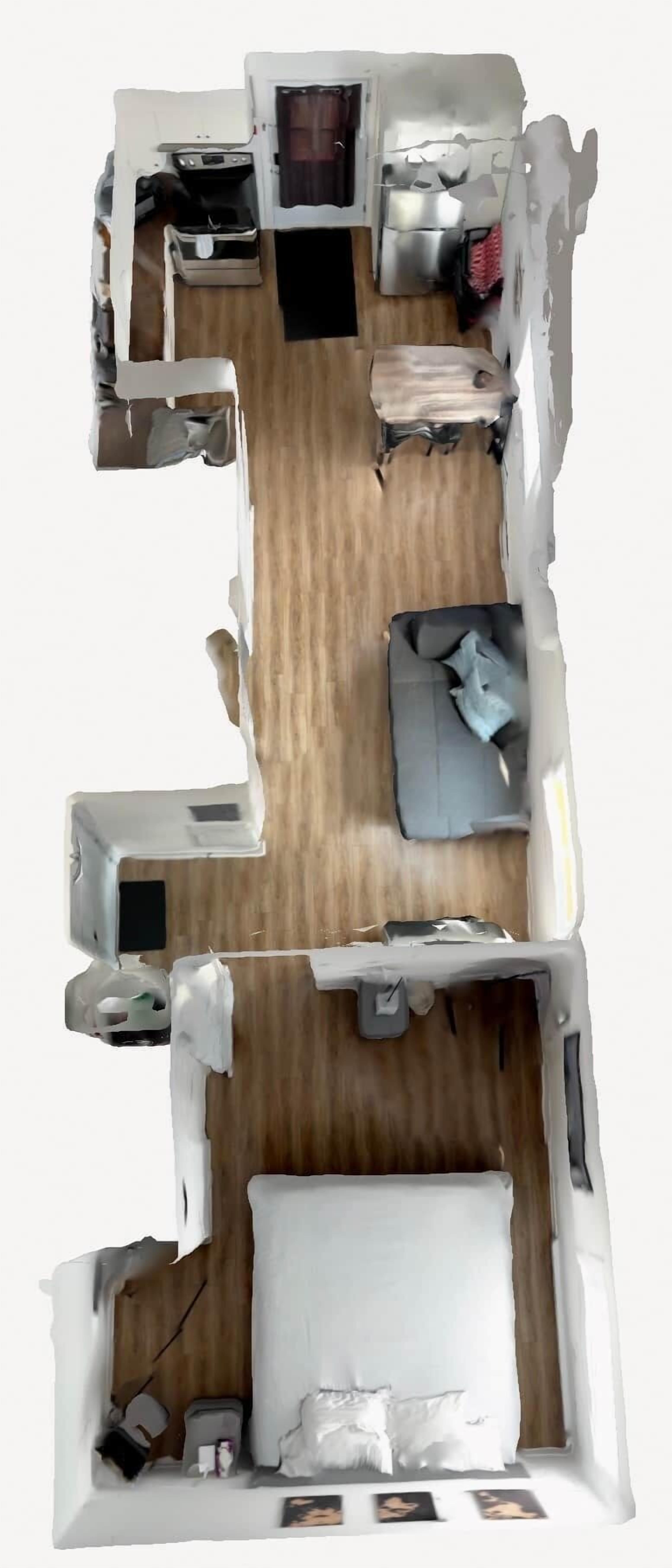 Vista cenital de una habitación de hotel con cama, escritorio, silla, mesita y armario.