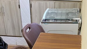 A compact kitchen with a wooden table and two wicker chairs. - Cocody Riviera 3, Splendid studio #04 quiet and peaceful residential area (Abidjan)