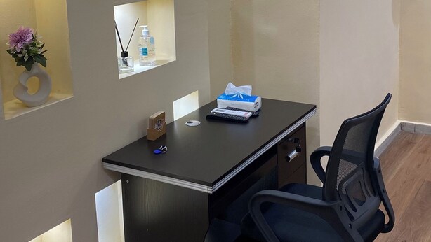 A modern office space with a desk, chair, and built-in shelves. - Cocody Riviera 3, Splendid studio #04 quiet and peaceful residential area (Abidjan)