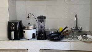 A kitchen with a coffee maker, slow cooker, blender, frying pan, and a sink. - Cocody Riviera 3, Splendid studio #04 quiet and peaceful residential area (Abidjan)