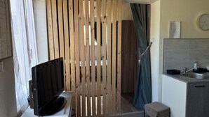 A compact kitchen with a sink, a small countertop, and a wooden partition. - Cosy and bright gîte with private pool for rent (Bollène)