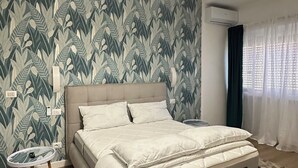 A bedroom with a large bed, a round table, and a ceiling light fixture. - St.Peter YH (Roma)