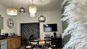 A modern kitchen with a dining area, wooden flooring, and pendant lighting. - St.Peter YH (Roma)