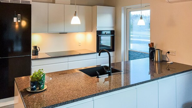 A modern kitchen with a granite countertop, stainless steel appliances, and pendant lighting. - Awesome home in Ringkøbing with WiFi (Ringkøbing)