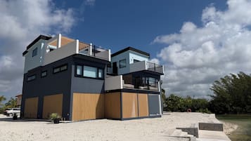 A modern multi-story building with a flat roof, large windows, and a balcony.
