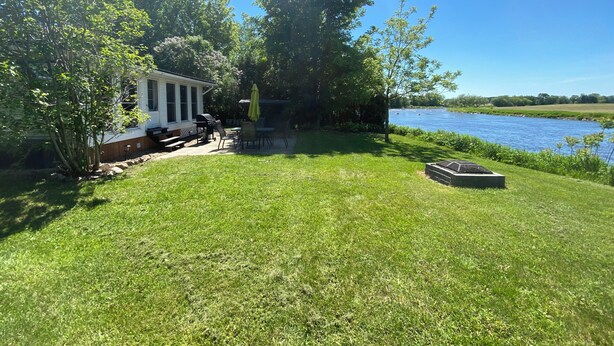 Una casa con veranda, barbecue e vista sul lago.