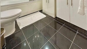 Ein modernes Badezimmer mit Toilette, Dusche und Waschbecken.