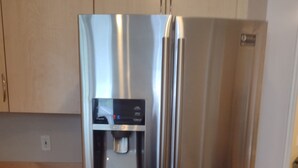 Un refrigerador de acero inoxidable con dispensador de agua y compartimento congelador.