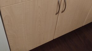 Un mueble de madera con dos cajones y dos puertas, cada una con un tirador metálico.