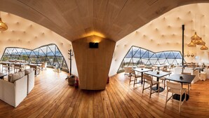A spacious interior with wooden flooring, multiple seating areas, and large windows offering views of the outdoors. - Moreno Camp - Glamping with a view (Perito Moreno)