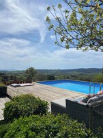 Una piscina al aire libre de temporada, sombrillas