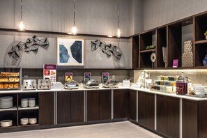 A modern breakfast bar with a variety of food items and a coffee station.