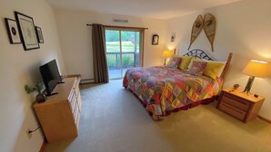 A bedroom with a bed, bedside tables, a dresser, a television, and a window with curtains. - Sc27 Family Style Bretton Woods Condo (Bretton Woods)