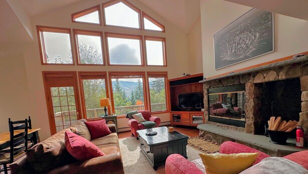 A spacious living room with large windows, a fireplace, and a television. - SH1 Beautiful Stonehill Townhouse in Bretton Woods (Bretton Woods)