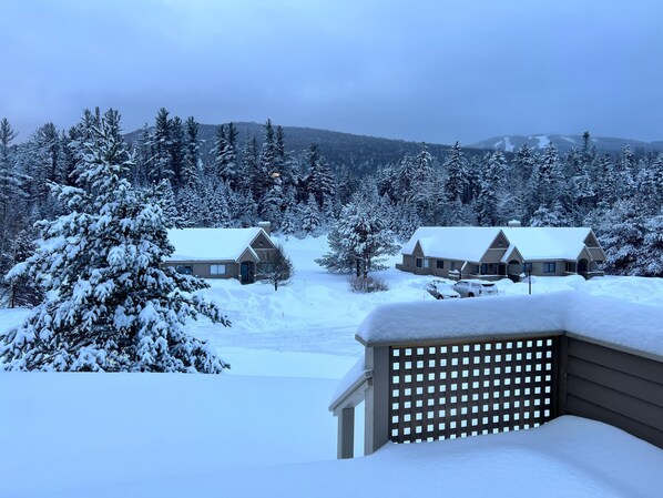 Paisaje nevado con dos cabañas y una valla de madera.