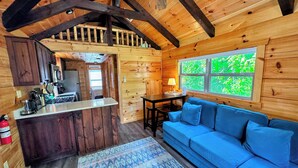 A log cabin interior with a kitchen, dining area, and living room. - Bmv7 Tiny Home Topline (Twin Mountain)