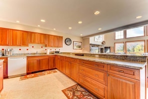A spacious kitchen with wooden cabinets, granite countertops, and a dishwasher. - SH4 Bretton Woods Condo With Hot Tub, Next to Skiing and Mt Washington Hotel, ski Slopes Views! (Bretton Woods)