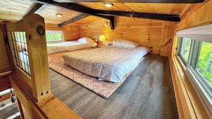 A cabin bedroom with two beds, a window, and a wooden ceiling. - Bmv6 Tiny Home Topline (Twin Mountain)