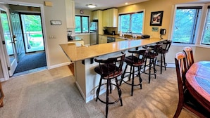 A kitchen with a central island, bar stools, and a dining table. - FV3 F3 Well Appointed Townhome a Short Walk to the Mount Washington Hotel (Bretton Woods)