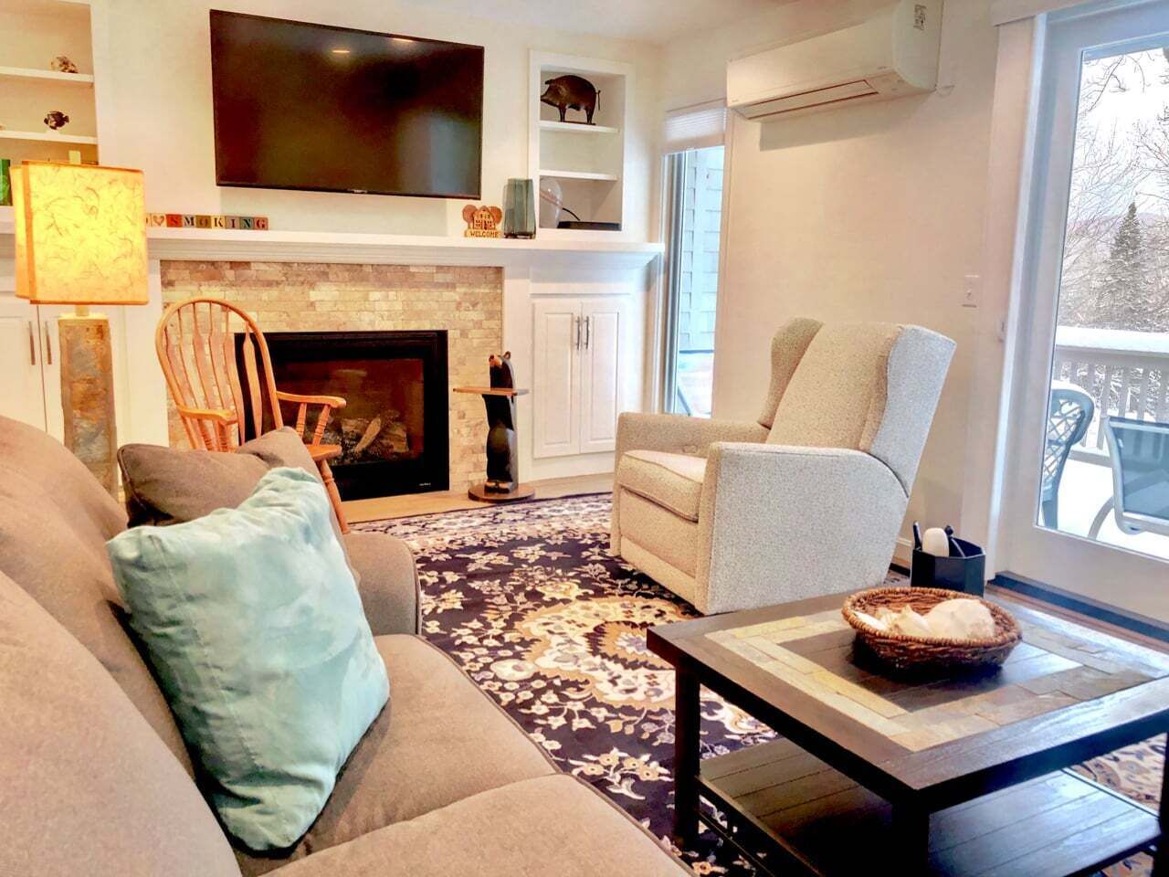 A living room with a fireplace, a television, a sofa, a chair, and a coffee table.