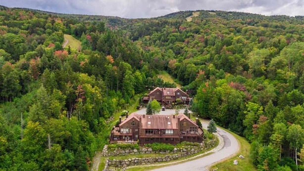 A lodge with a stone foundation, multiple buildings, and a winding road. - V3 Gorgeous Ski-in Mountain View Townhouse With Amazing Views in Bretton Woods (Bethlehem)